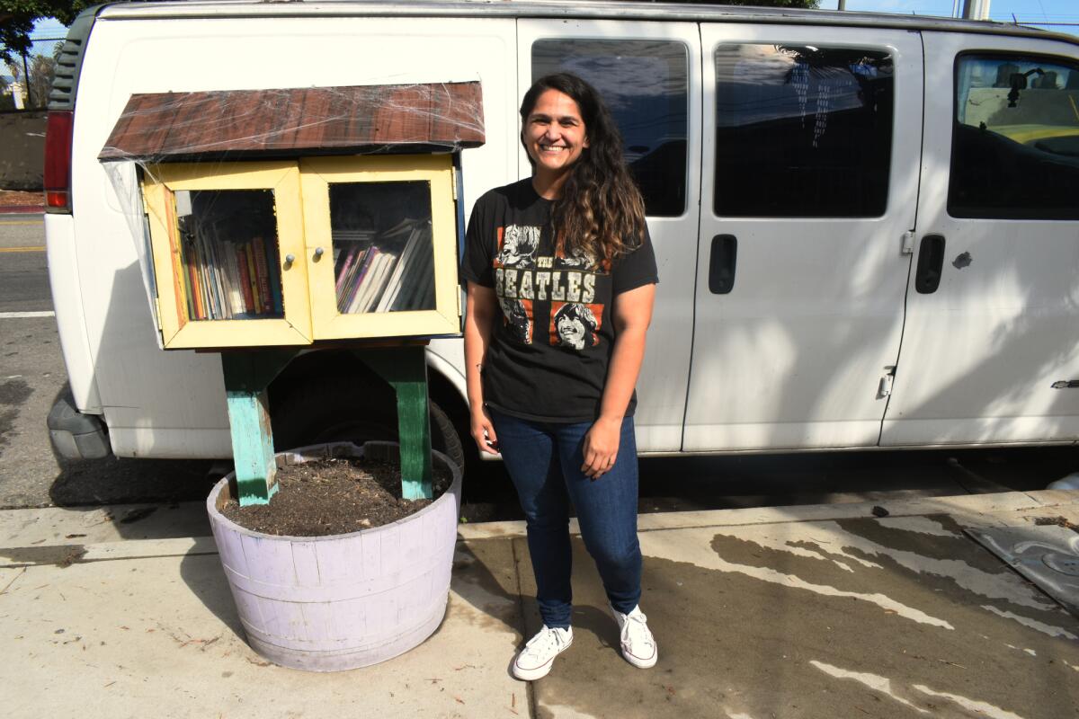 Veronica Casarez, a community organizer and Bass supporter, poses next to a tiny library in Boyle Heights.