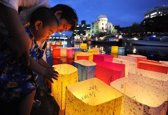 A boy and his grandmother in Hiroshima, Japan, prepare paper lanterns to be set afloat as a comforting gesture to the souls of the 140,000 people killed when the U.S. dropped the atomic bomb on Hiroshima on Aug. 6, 1945.