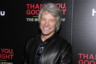 Jon Bon Jovi smiles in a black leather jacket and black shirt