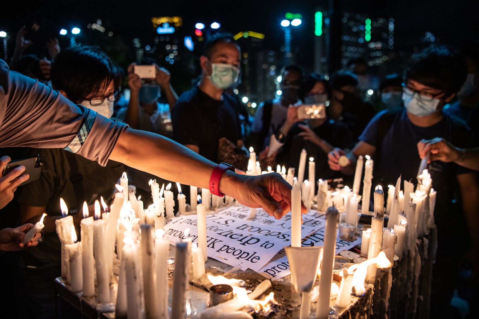 Candles surround a sign appealing to U.S. troops for help as Hong Kong marks Tiananmen Square anniversary. 