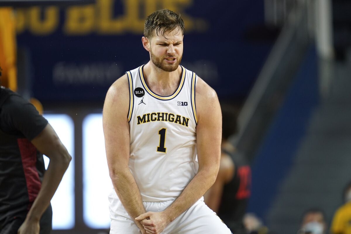 Michigan center Hunter Dickinson (1) reacts to hitting three-point basket against San Diego State in the first half of an NCAA college basketball game in Ann Arbor, Mich., Saturday, Dec. 4, 2021. (AP Photo/Paul Sancya)