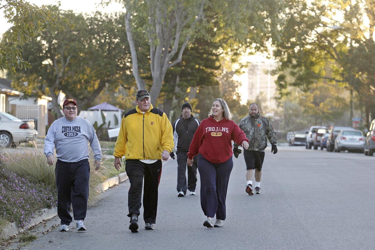Costa Mesa Mayor Jim Righeimer, Mayor Pro Tem Steve Mensinger, former city employee Tim Sweet, local resident Kristen Kirk and Estancia High football coach Mike Bargas, from left to right, make their way through Arbor Street, headed to Canyon Community Park, during an early morning walk.