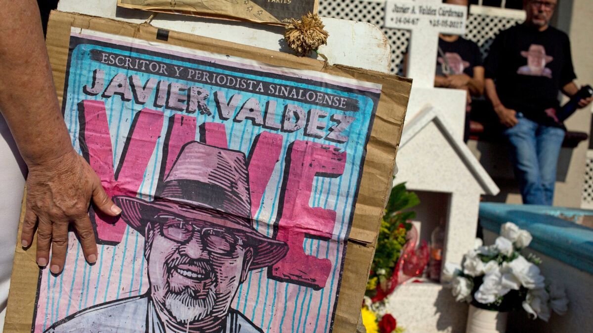 Relatives of slain journalist Javier Valdez Cardenas, cofounder of Riodoce, stand at a memorial set up at the spot where he was gunned down in Culiacan, Sinaloa.
