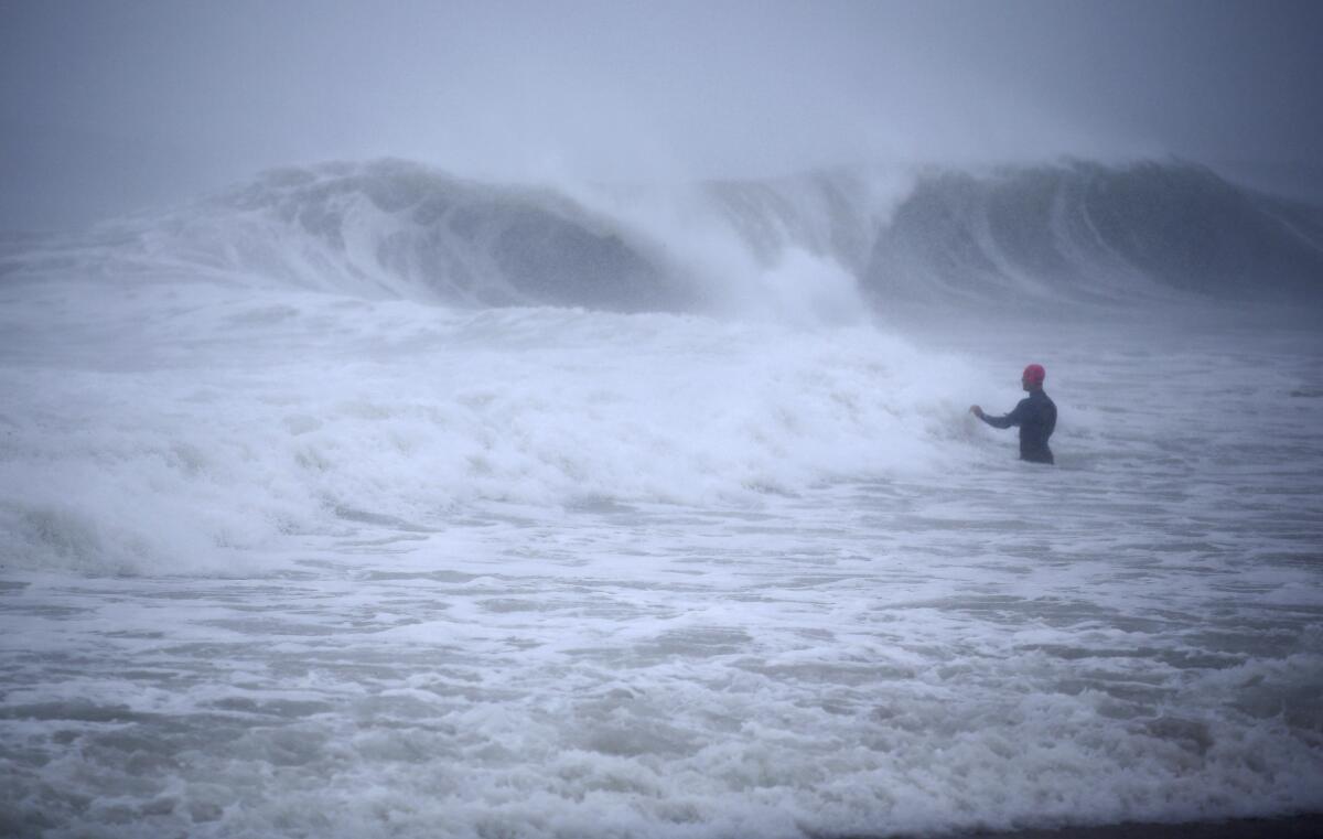 A man walks in the ocean.