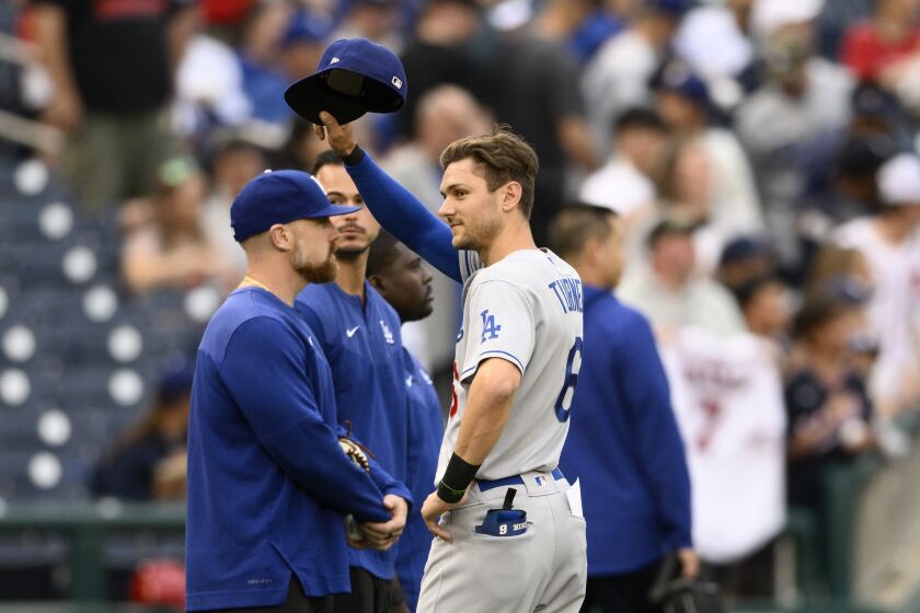 Los Angeles Dodgers' Trea Turner doffs his cap to the crowd as he is recognized with a tribute video before a baseball game against the Washington Nationals, Monday, May 23, 2022, in Washington. (AP Photo/Nick Wass)