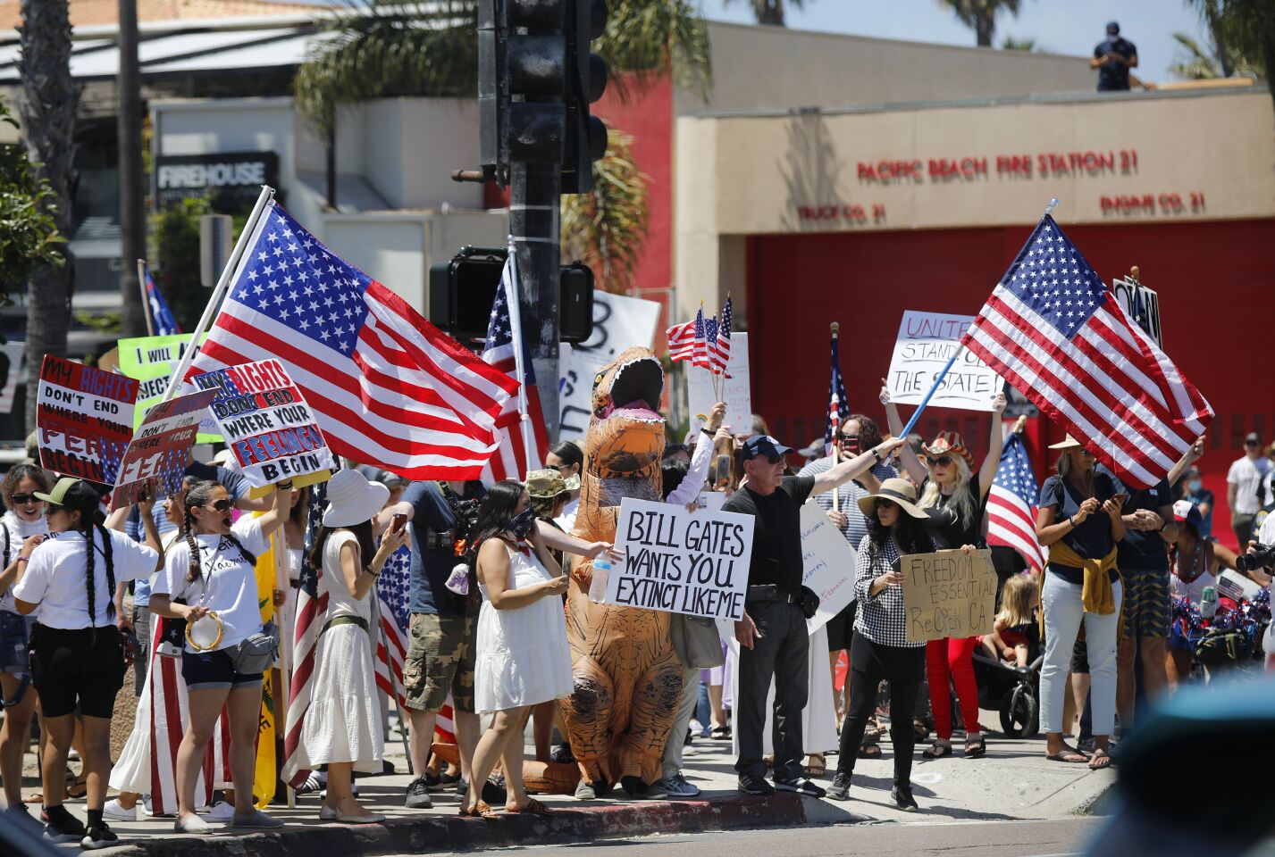 Protesters stand along Mission Blvd. in Pacific Beach during A Day of Liberty rally on Sunday, April 26, 2020. The protesters were against the government shutdown due to the coronavirus.