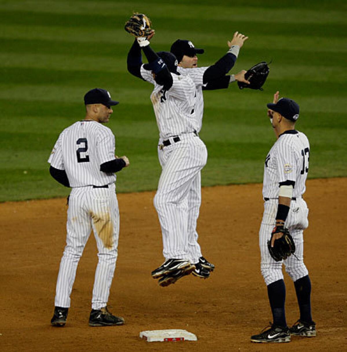 The New York Yankees celebrate their 4-1 victory over the Angels in Game 1 of the American League Championship Series on Friday night at Yankee Stadium.