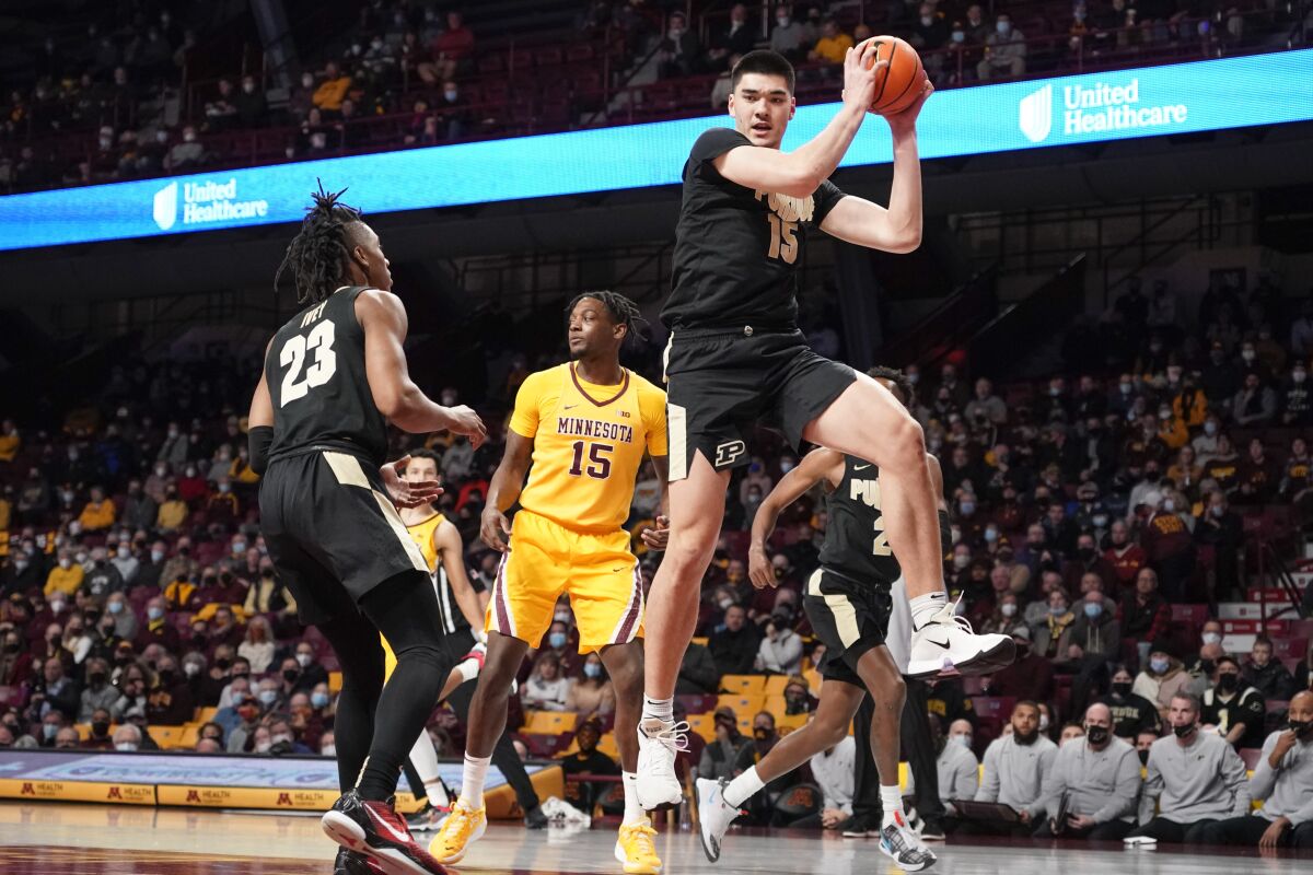 Purdue center Zach Edey, right, grabs a rebound near Purdue guard Jaden Ivey, left, and Minnesota forward Charlie Daniels (15) during the first half an NCAA college basketball game Wednesday Feb. 2, 2022, in Minneapolis. (AP Photo/Craig Lassig)