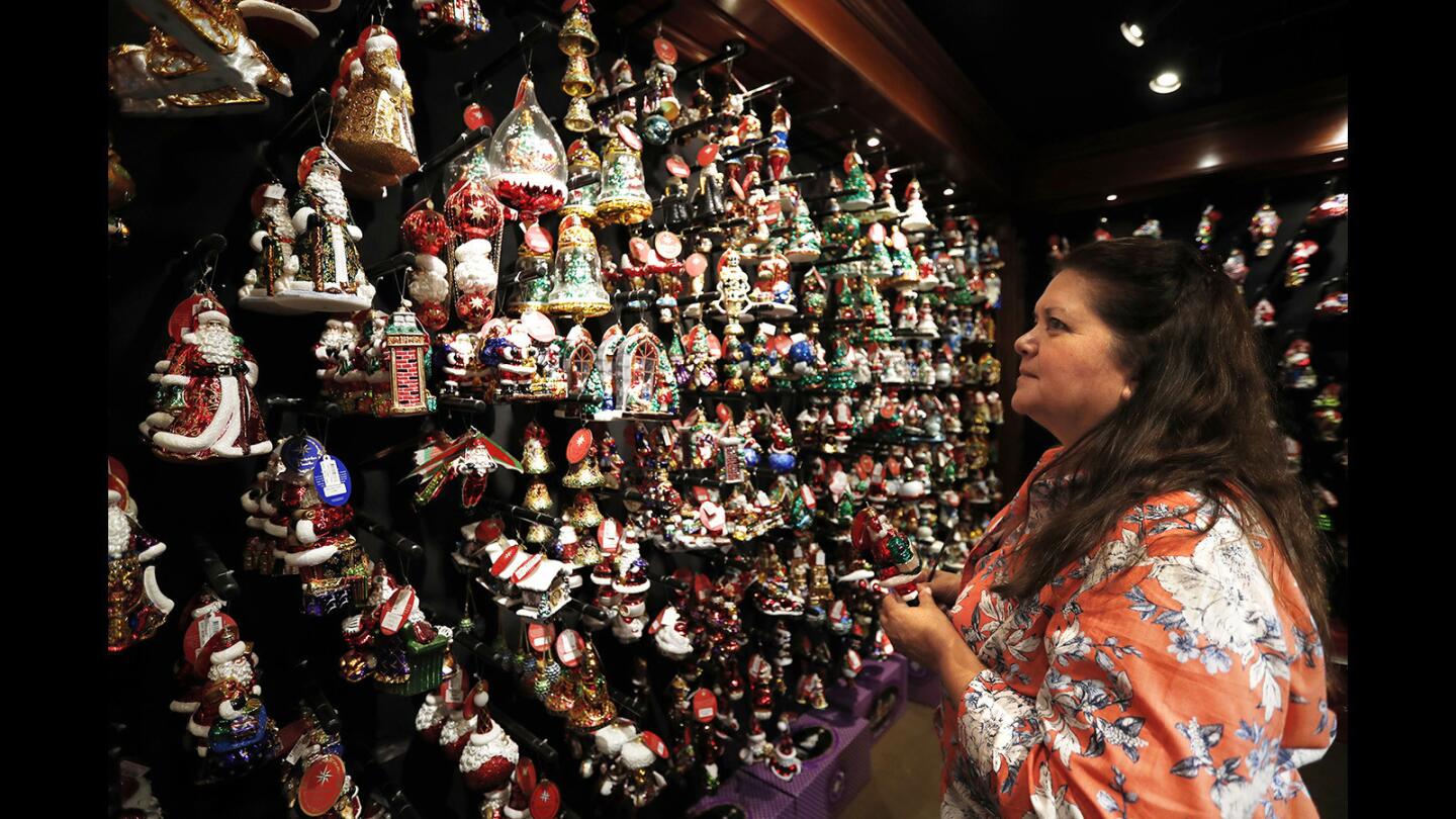 Debbie Tuner of Lawndale looks at ornaments Wednesday during a preview for invited guests at the Christmas boutique at Roger's Gardens in Corona del Mar. The boutique opens to the public Friday.