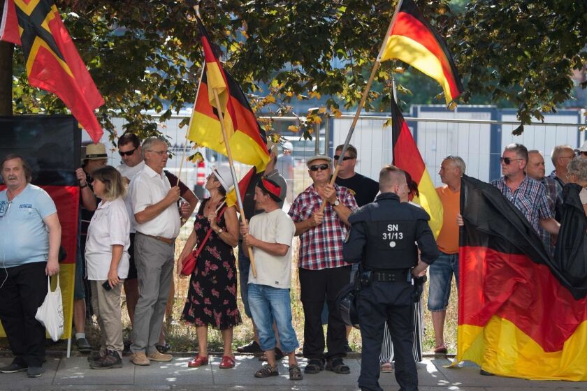 This picture taken on August 16, 2018 in Dresden, eastern Germany, shows anti-Islam Pegida movement supporters demonstrating on the occasion of German Chancellor's visit at the Saxon state parliament. - A free-speech scandal about German police obstructing a TV crew at a far-right rally against Chancellor Angela Merkel escalated August 23, 2018, after news that the protester who sparked the incident was an off-duty police employee. (Photo by Sebastian Kahnert / dpa / AFP) / Germany OUTSEBASTIAN KAHNERT/AFP/Getty Images ** OUTS - ELSENT, FPG, CM - OUTS * NM, PH, VA if sourced by CT, LA or MoD **