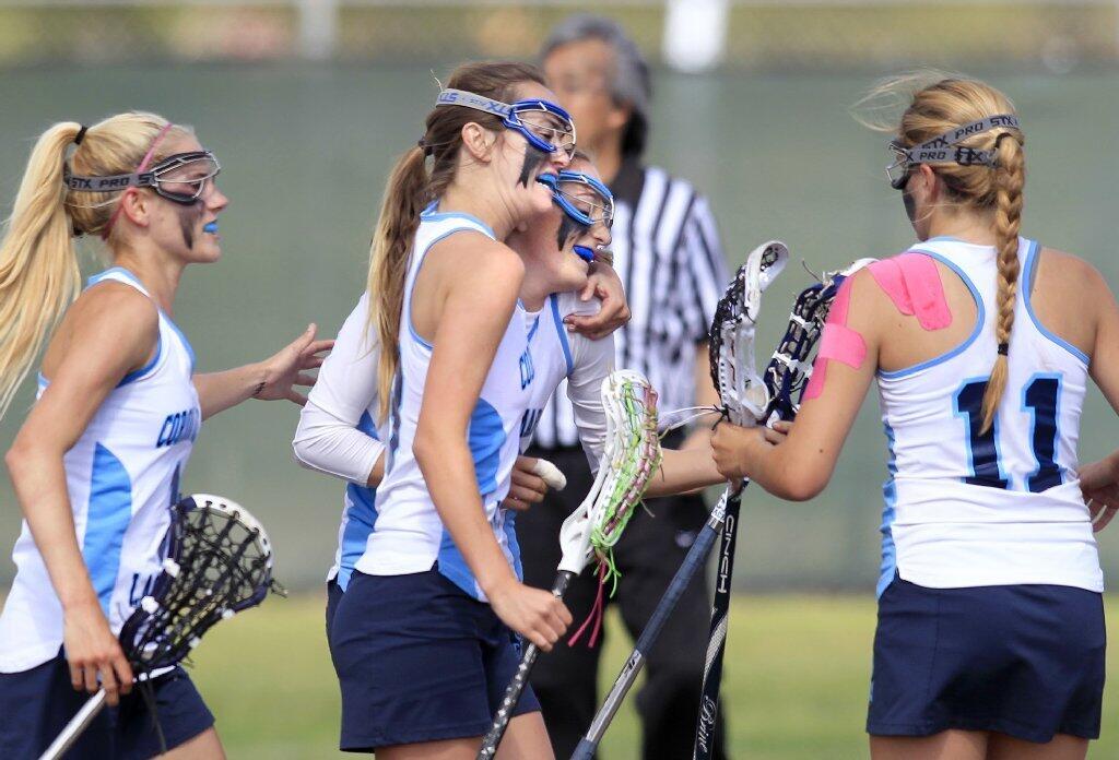 Corona del Mar High's Kennedy Mulvaney, center right, is congratulated on a goal by teammates Kacie Kline, center left, Payton Carter, left, and Jamie Smith, right, against Newport Harbor during the Battle of the Bay game on Friday.
