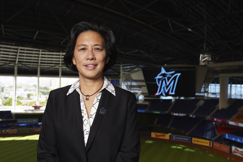 In this photo provided by the Miami Marlins, new Miami Marlins general manager Kim Ng poses for a photo at Marlins Park stadium before being introduced during a virtual news conference, Monday, Nov. 16, 2020, in Miami. Ng discussed her climb to become the first female GM in the four major North American professional sports leagues. (Joseph Guzy/Miami Marlins via AP)