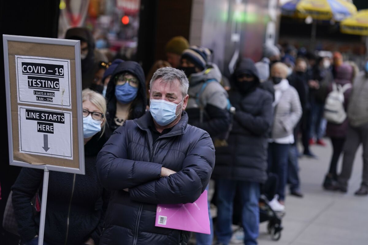 People wait in line at a COVID-19 testing site in New York City's Times Square. 