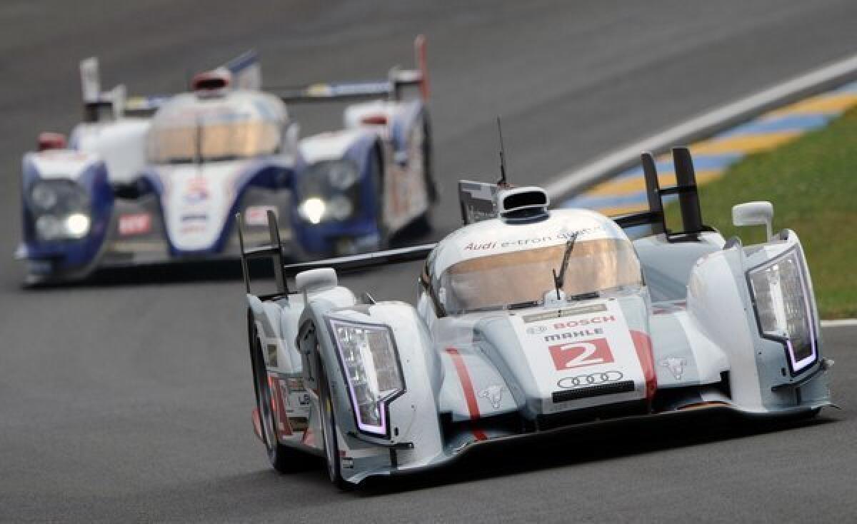 The Audi R18 E-Tron Quattro Hybrid driven by Scotland's Allan McNish competes ahead of the Toyota TS030 Hybrid driven by Austria's Alexander Wurz during the free practice session of the 90th edition of the 24 Hours of Le Mans in western France.