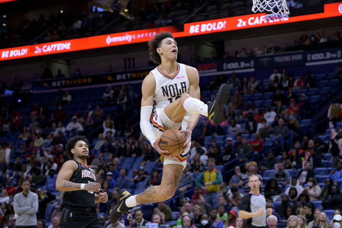New Orleans Pelicans center Jaxson Hayes, right, goes up for a dunk against Houston Rockets guard Daishen Nix, left, in the second half of an NBA basketball game in New Orleans, Sunday, March 13, 2022. (AP Photo/Matthew Hinton)