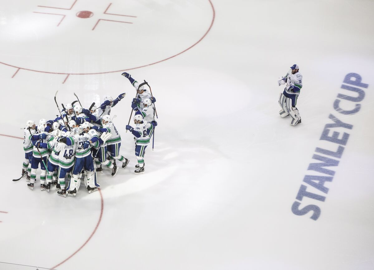 Vancouver Canucks players celebrate a goal against the Minnesota Wild during the third period of an NHL hockey qualifying round game, Friday, Aug. 7, 2020, in Edmonton, Alberta. (Jason Franson/The Canadian Press via AP)