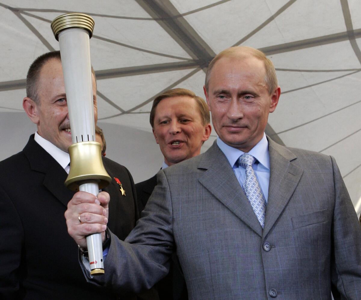 Russian President Vladimir Putin in 2007 holds one of the torches produced for the 1980 Moscow Olympics. Ahead of the Sochi Olympic games this week, more than 200 authors called on the Russian leader to repeal laws that limit freedom of expression.