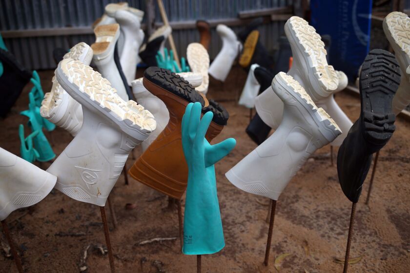 Sanitized gloves and boots hang to dry as a burial team collects Ebola victims from a Ministry of Health treatment center for cremation on Oct. 2 in Monrovia, Liberia.