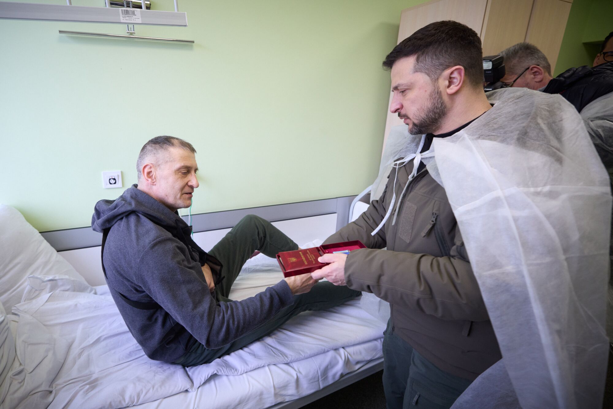 Ukrainian President Volodymyr Zelensky visits injured soldiers to manus retired medals.