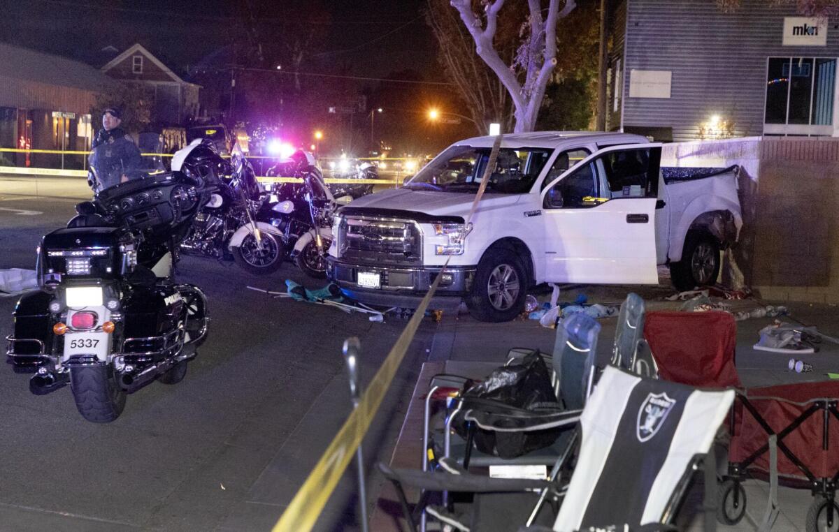 A pickup truck and police motorcycles on a street at night.