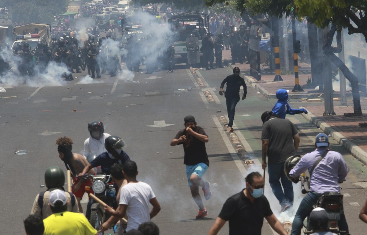 La policía lanza gases lacrimógenos para dispersar a los manifestantes durante una protesta 