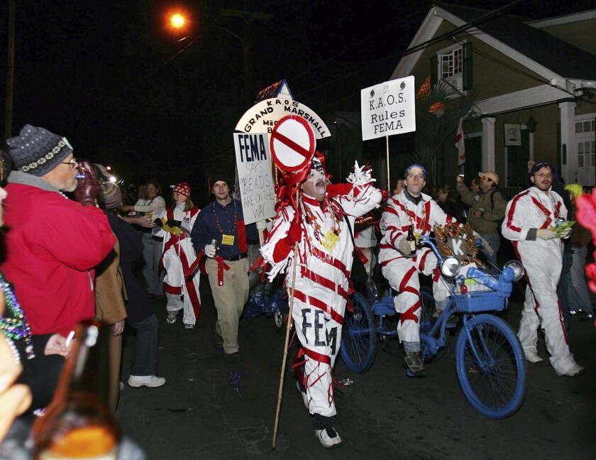 FILE - The satirical Krewe du Vieux parade makes its way through the French Quarter as it laughs at authorities and tragedy of Hurricance Katrina and aftermath, Saturday, Feb. 11, 2006, in New Orleans. New Orleans’ health director says she won’t take part in one of the earliest of the Mardi Gras season parades in 2022, citing threats after the resumption of COVID-19 restrictions in the city. (AP Photo/Mary Ann Chastain, File)