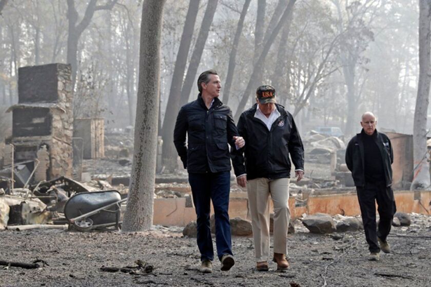 FILE - In this Nov. 17, 2018 file photo, President Donald Trump talks with California Gov.-elect Gavin Newsom, left, as California Gov. Jerry Brown, walks at right during a visit to a neighborhood destroyed by the Camp wildfire in Paradise, Calif. Newsom is declaring a state of emergency to speed up forest management ahead of the next wildfire season and will sign an order Friday, March 22, 2019, allowing fire officials to bypass certain environmental and other regulations in order to clear dead trees and vegetation more quickly. It will apply to 35 projects across 90,000 acres of land. (AP Photo/Evan Vucci, File)