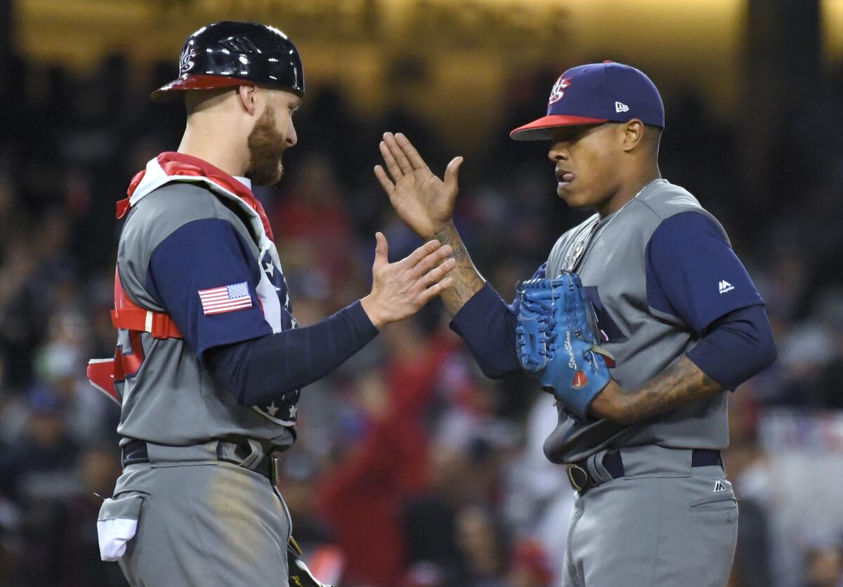 U.S. catcher Jonathan Lucroy, left, greets pitcher Marcus Stroman in the sixth inning against Puerto Rico during the final of the World Baseball Classic. in Los Angeles, Wednesday, March 22, 2017. (AP Photo/Mark J. Terrill)