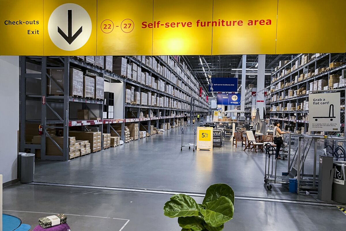 The warehouse-like aisles of an Ikea store's self-service area filled floor to ceiling with boxes