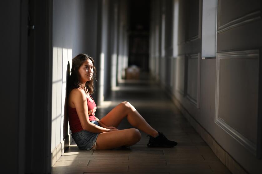 LOS ANGELES, CALIFORNIA AUGUST 18, 2020-USC student Alexis Timko sits in the hallway outside her apartment near the Trojan campus as classes are completely online. (Wally Skalij/Los Angeles Times)