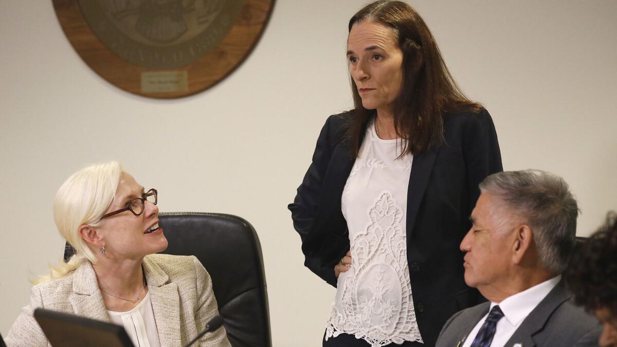 Independent Assessor Sue Stengel, center, talks to Los Angeles Commissioners Rebecca Ninburg, left, and Jimmy H. Hara, right, before the Board of Fire Commissioners meeting Tuesday.