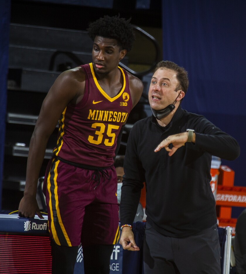 Minnesota forward Isaiah Ihnen (35) stands next to head coach Richard Pitino courtside in the first half of an NCAA college basketball game against Michigan at Crisler Center in Ann Arbor, Mich., Wednesday, Jan. 6, 2021. (AP Photo/Tony Ding)
