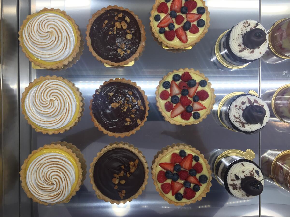 Lemon, chocolate hazelnut and fruit tarts, from left, as well as black forest cake inside the refrigerated case at D'Liteful Chocolat Patisserie & Chocolatier in Lake San Marcos. 