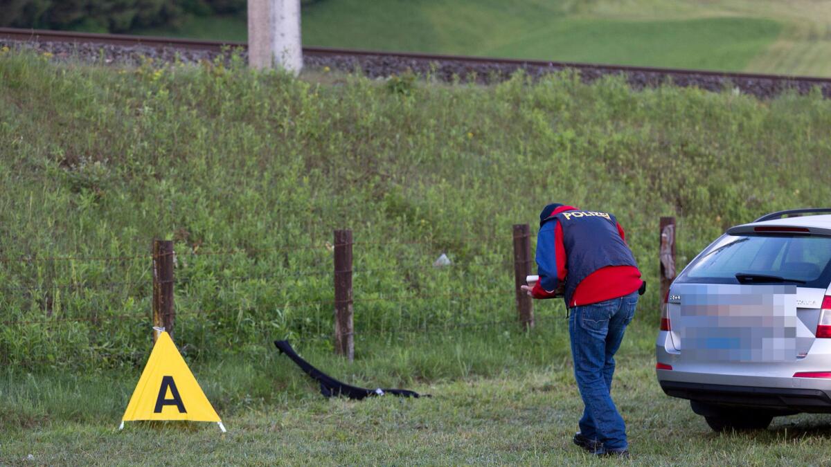 A police investigator examines evidence at the scene of a shooting in Nenzing, Austria.