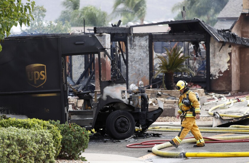A firefighter walks by debris of a fatal plane crash in Santee on Oct. 11, 2021. The Burn Institute is honoring local heroes.
