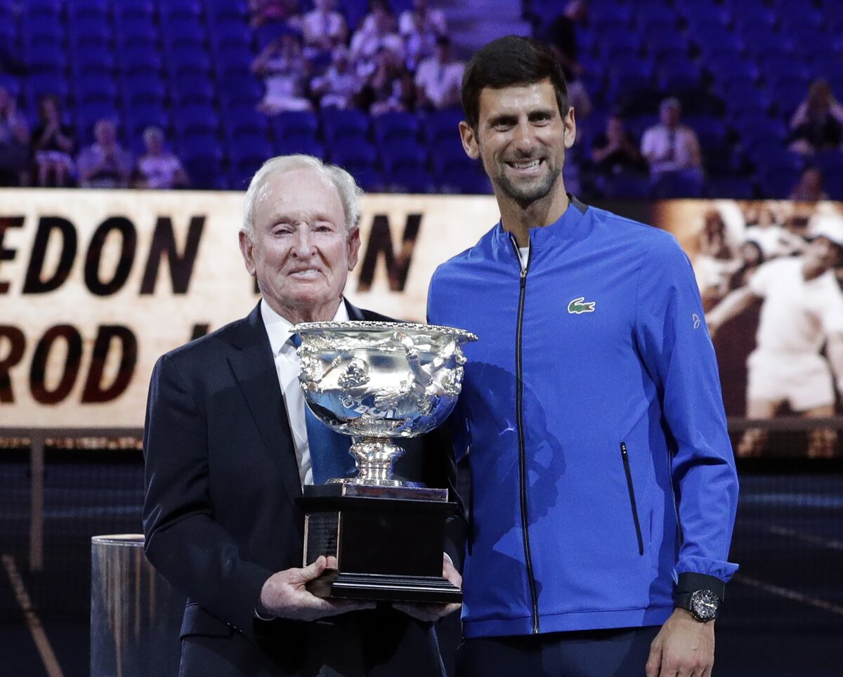 Rod Laver presents Novak Djokovic the Australian Open trophy in 2019.
