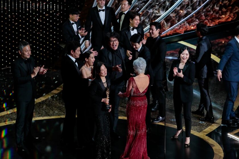 Presenter Jane Fonda congratulates the cast of “Parasite,” winners of the best picture Oscar on stage during the telecast of the 92nd Academy Awards.