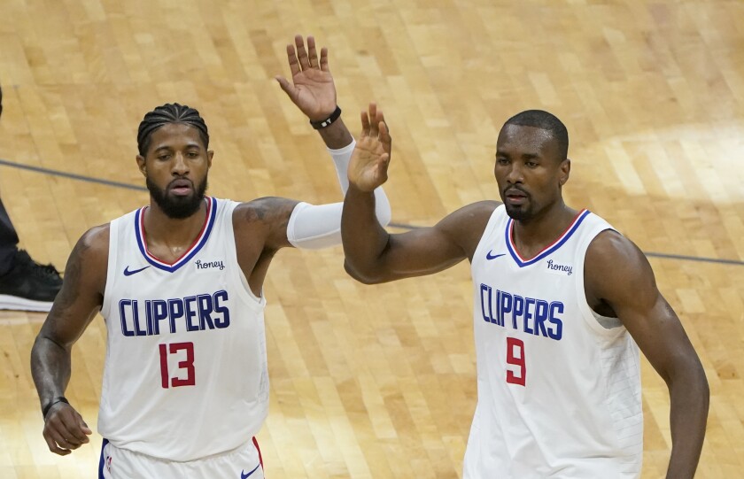 Clippers teammates Paul George, left, and Serge Ibaka celebrate during a 138-100 victory over the Sacramento Kings on Friday