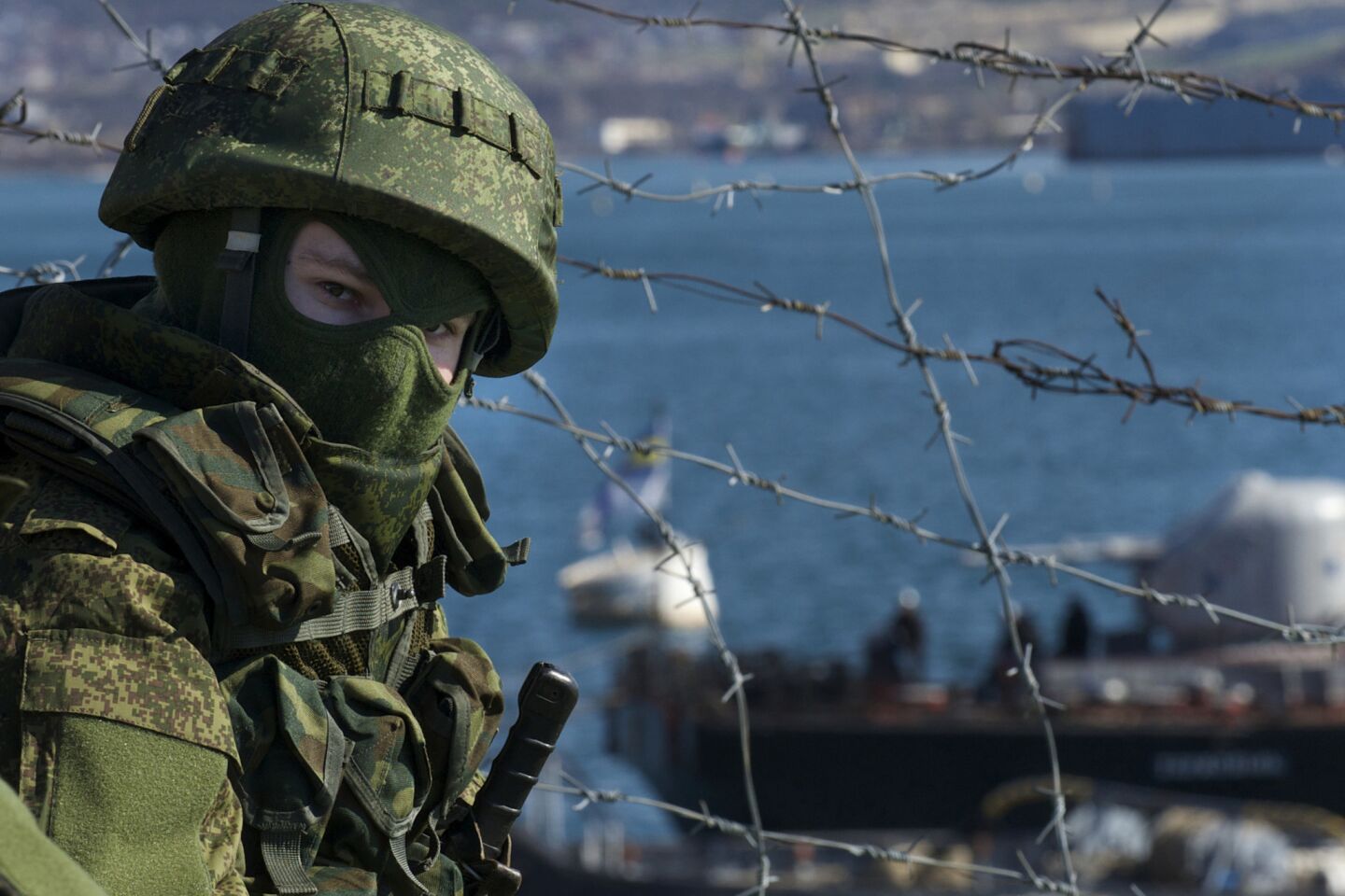 Russian soldiers guard a pier where two Ukrainian naval ships are moored near Sevastopol.