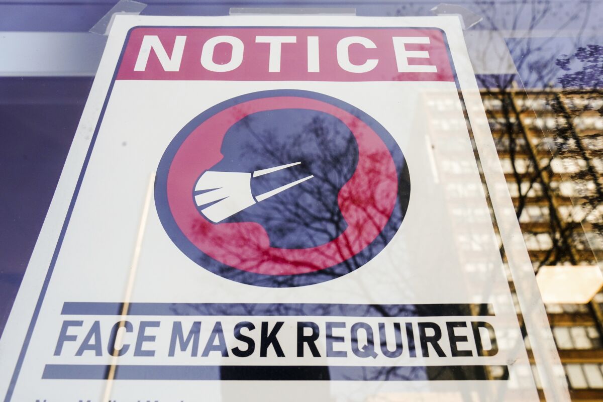 A sign informs store visitors that face masks are required inside.