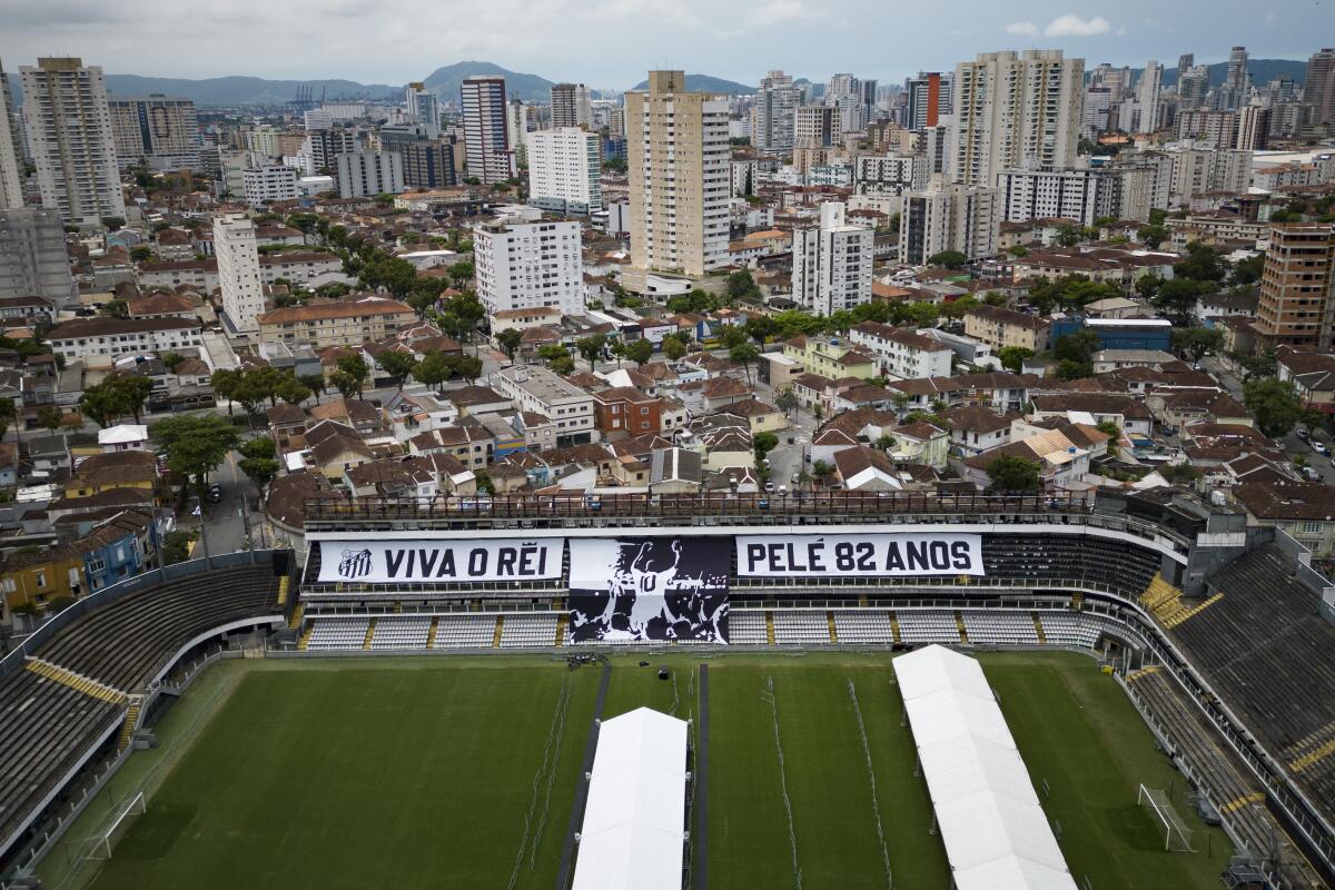 Giant banners that read in Portuguese: "Long live King Pele, 82 years", are displayed in the stands of the Vila Belmiro stadium, home of the Santos soccer club, where Pele's funeral will take place, in Santos, Brazil, Saturday, Dec. 31, 2022. Pele, who played most of his career with Santos, died in Sao Paulo on Thursday at the age of 82. (AP Photo/Matias Delacroix)