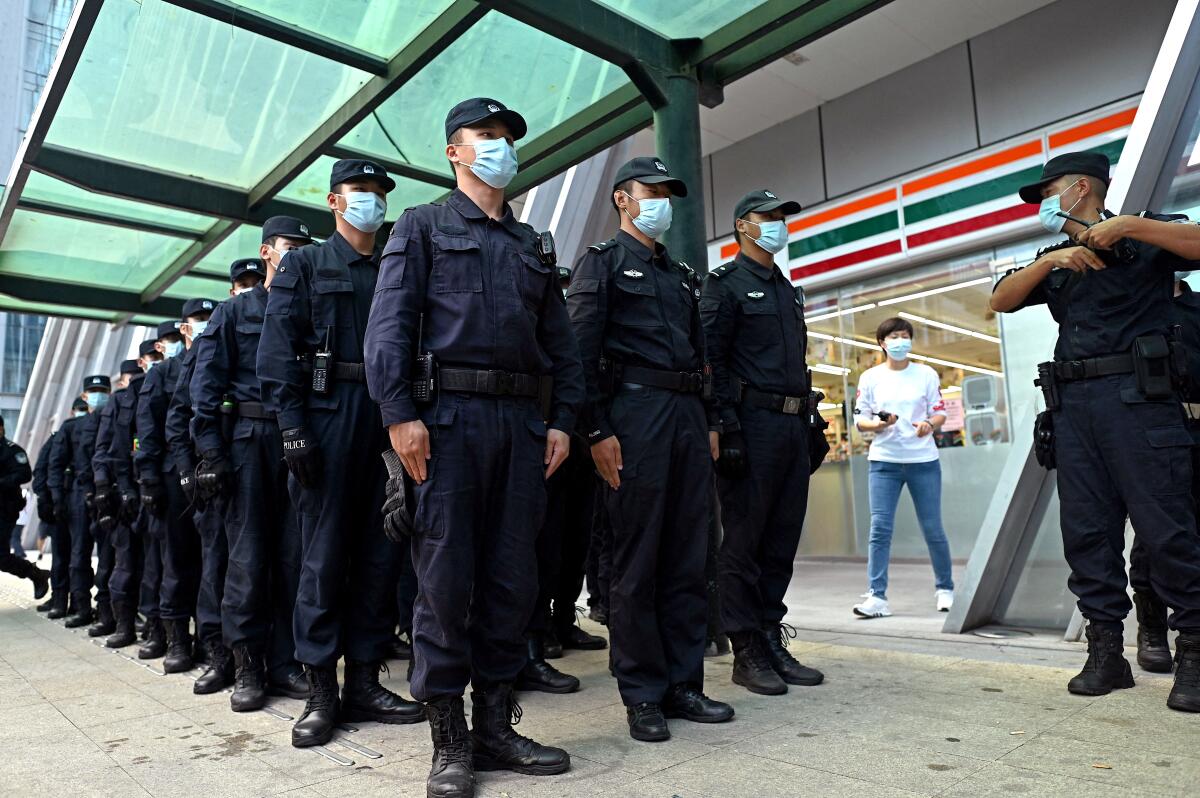 Policemen stand in formation at the Evergrande headquarters