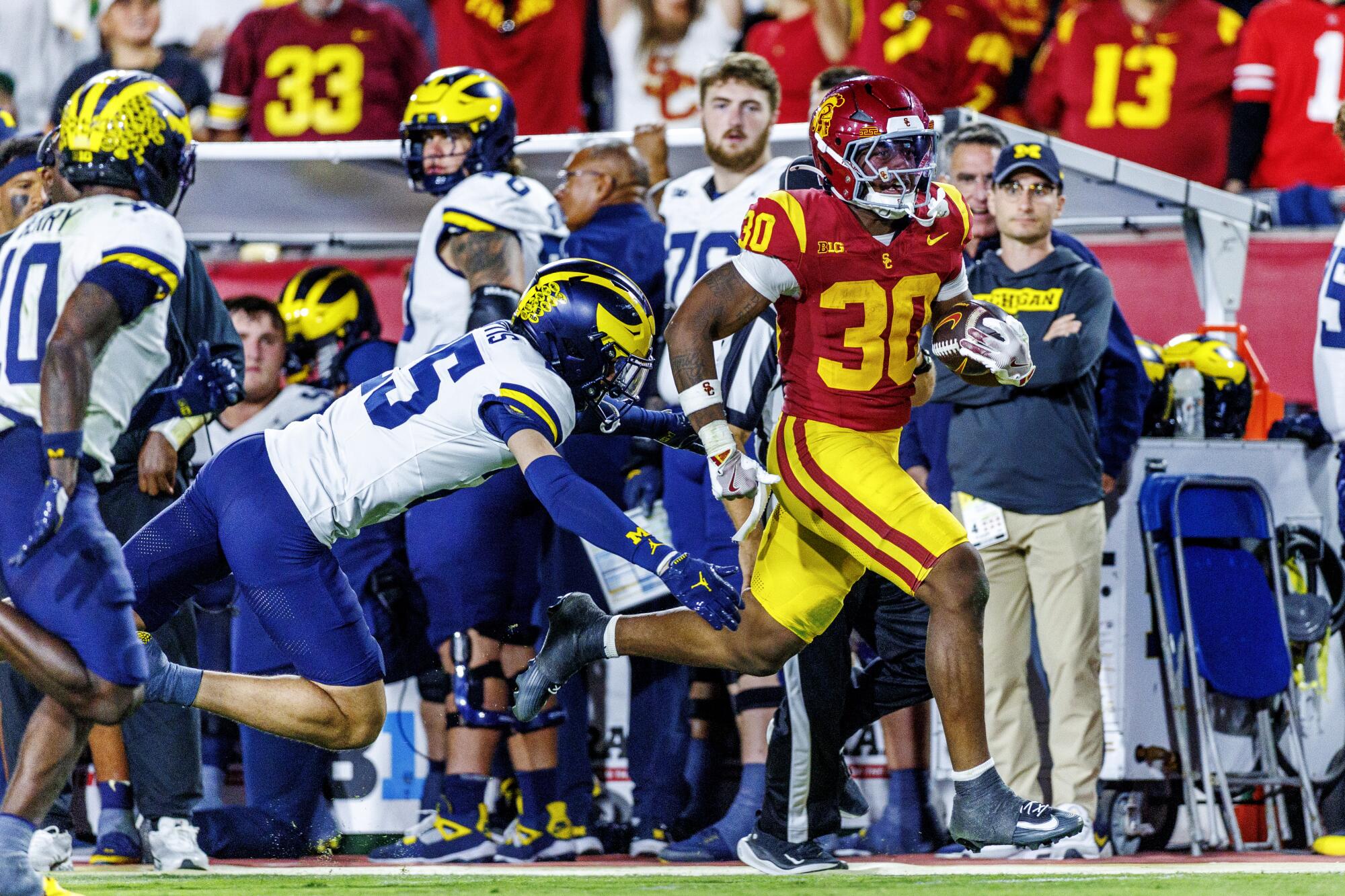 USC running back King Miller evades Michigan defensive back Mason Curtis on a 49-yard run at the Coliseum.