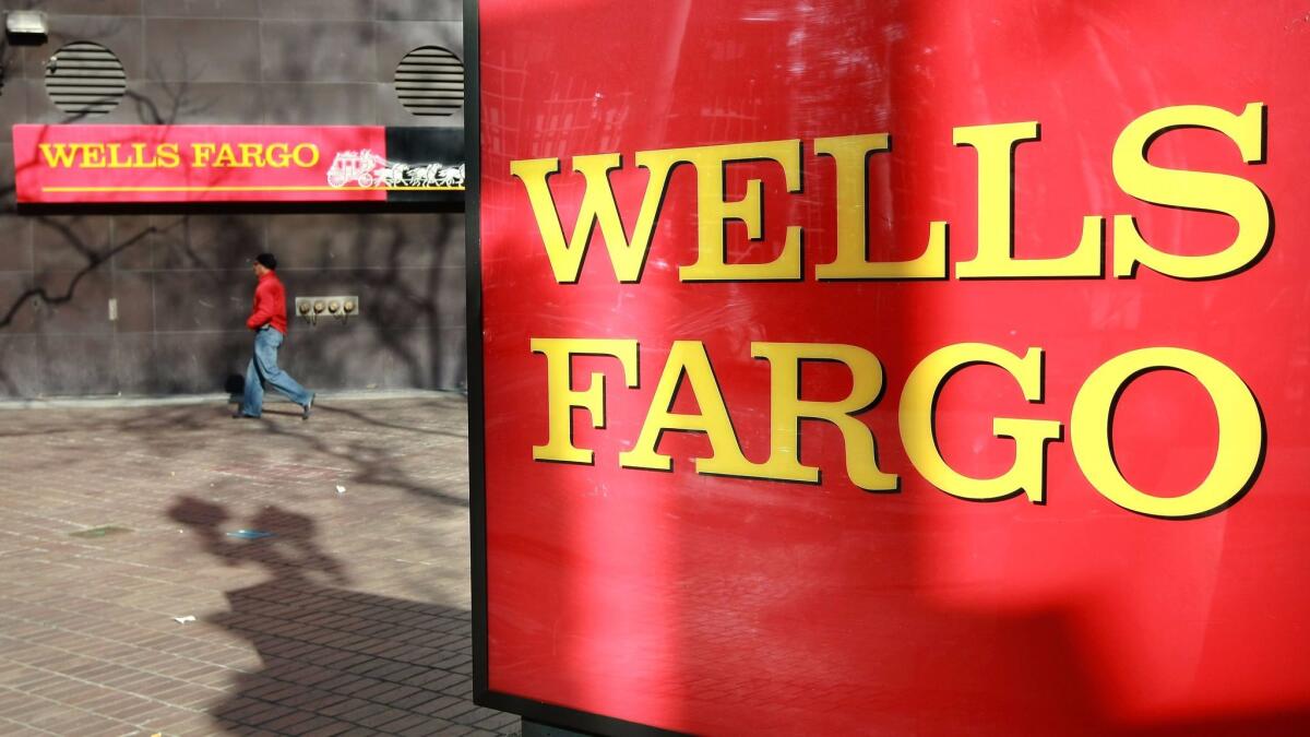 A pedestrian walks past a sign outside a Wells Fargo bank branch on Jan. 28, 2009, in Oakland.