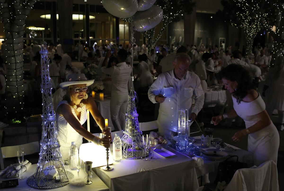 Diners, all dressed in white, decorate their own tables at Diner en Blanc 2016 in downtown Los Angeles.