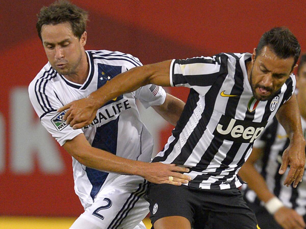 Galaxy defender Todd Dunivant, left, and Juventus forward Fabio Quagliarella battle for the ball on Aug. 3., 2013.