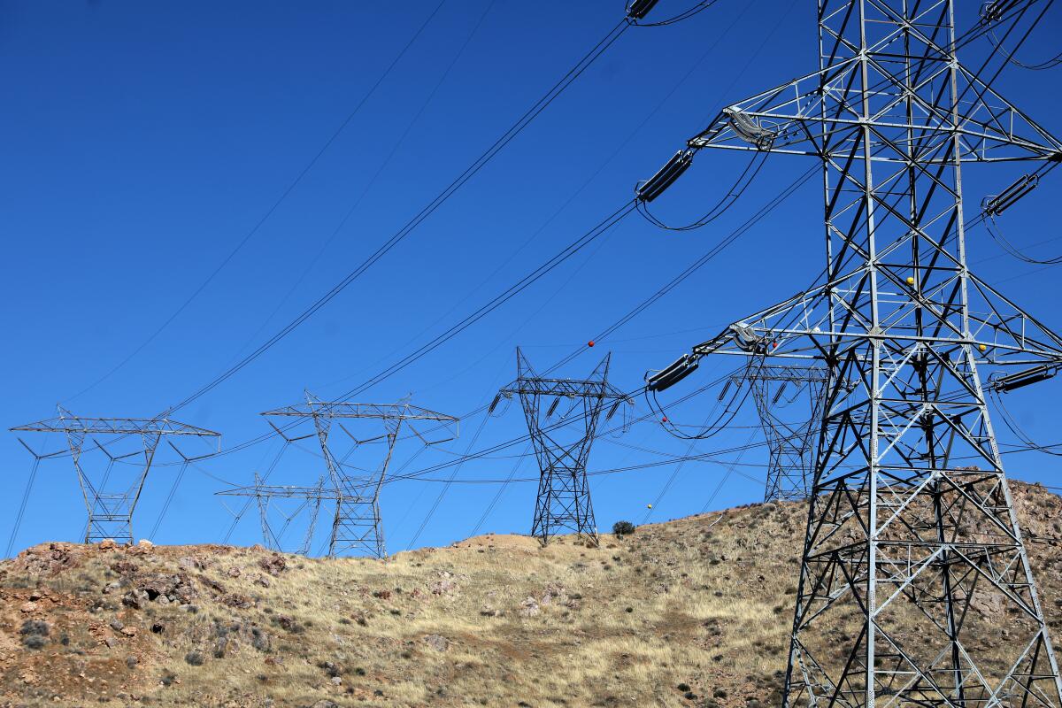 Electric transmission lines are seen on a hill.