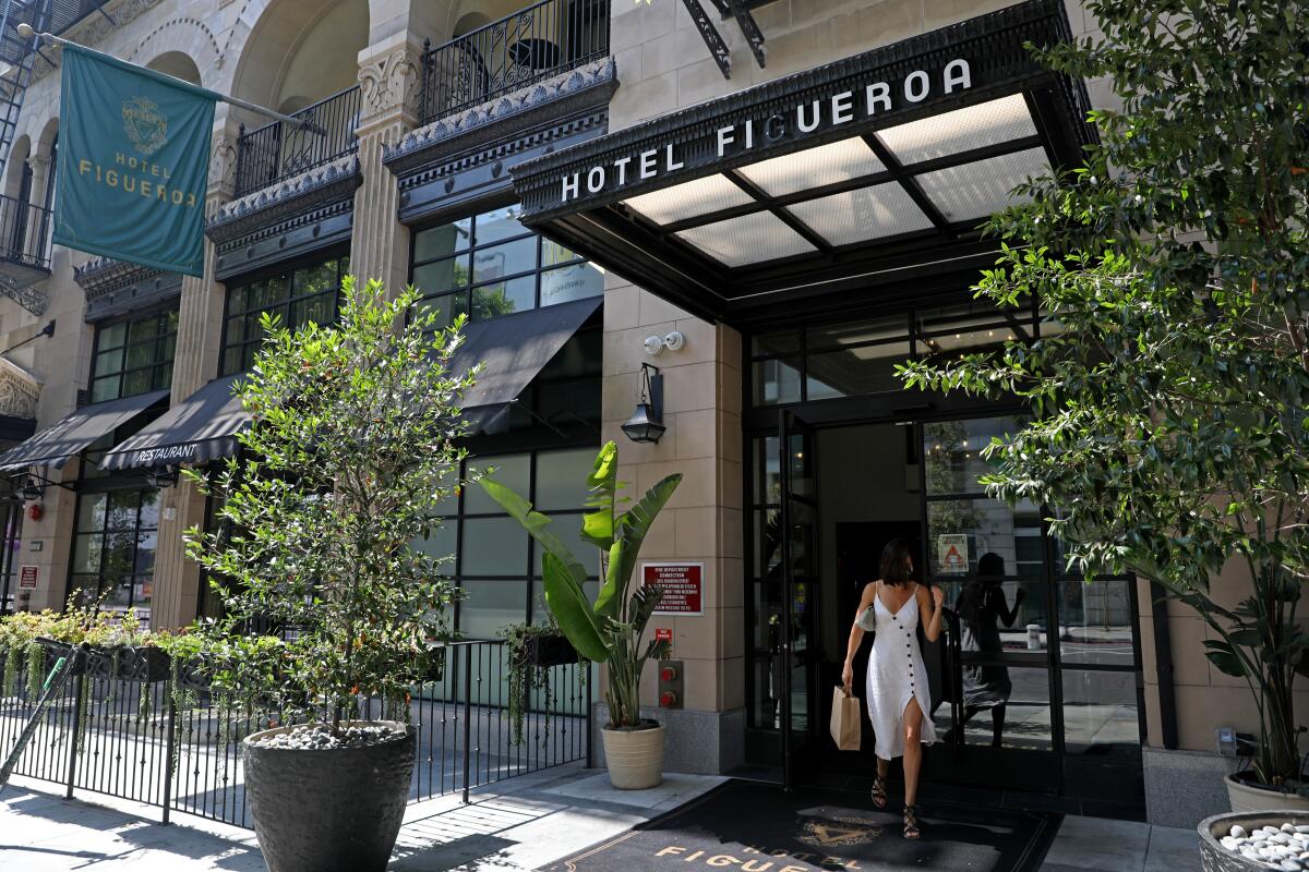 A person exits Hotel Figueroa 