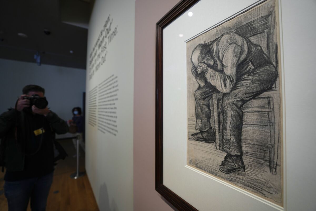 A photographer takes pictures of Study for "Worn Out", a drawing by Dutch master Vincent van Gogh, dated Nov. 1882, on public display for the first time at the Van Gogh Museum in Amsterdam, Netherlands, Thursday, Sept. 16, 2021. (AP Photo/Peter Dejong)