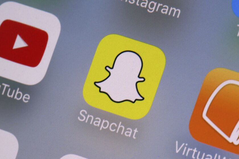 FILE- This Aug. 9, 2017, file photo shows the Snapchat app on a mobile device in New York. Snapchat is joining the online-games bandwagon with a new service that lets people play together on its mobile platform. The company says it wants to make it easier for friends to play together. (AP Photo/Richard Drew, File)